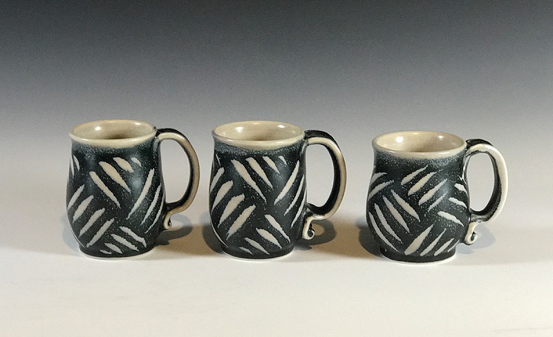 Joanne Kirkland, 4”h x 3.5” w. The black glaze overlapping the tan glaze which has rutile in it causes tiny crystals to form and creates a visual texture or mottling. Photo by Joanne Kirkland