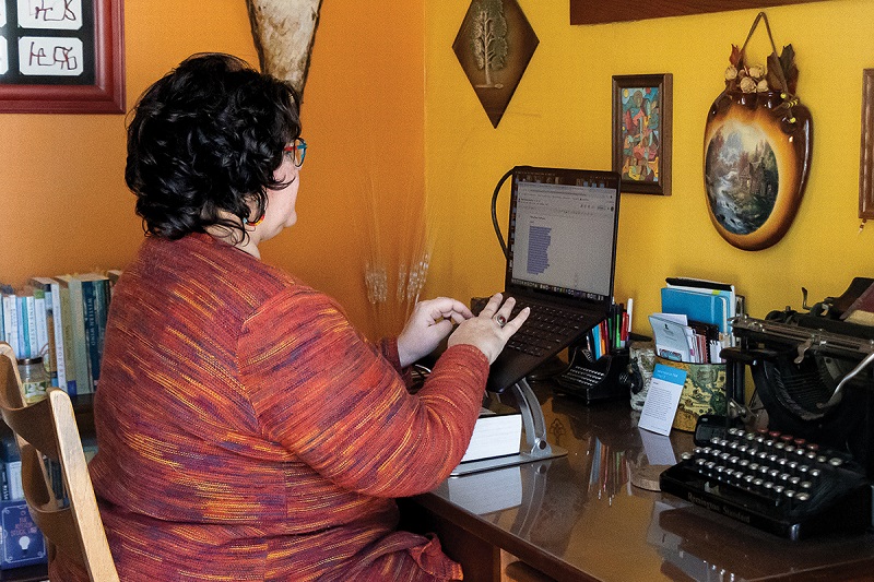 Cárdenas writes in her home office while surrounded by a lifetime of collected art. TJ Lambert, Stages Photography