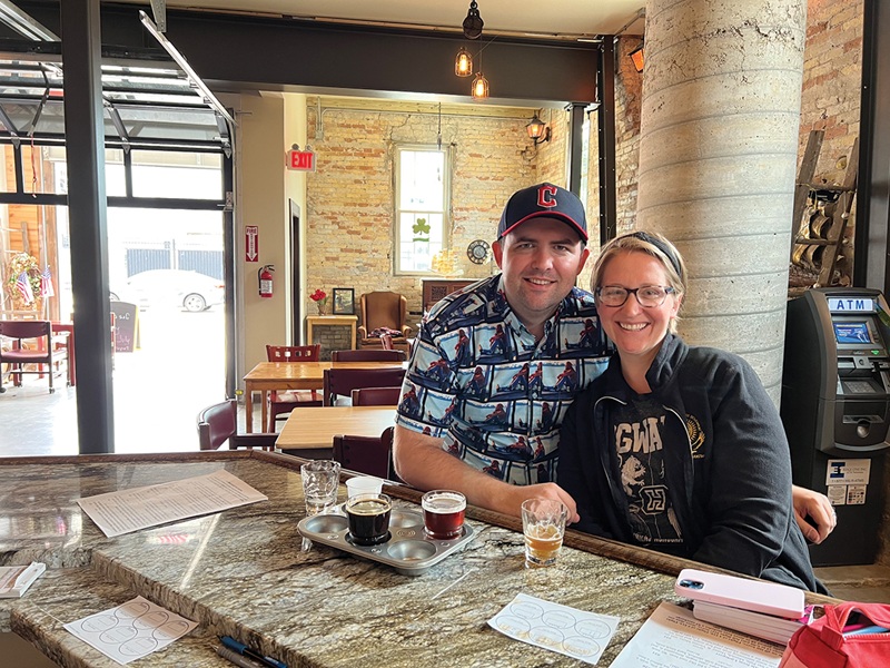 Author Heather Kerrigan and her husband at Littleport Brewing Company in Racine. They traveled 2,600 miles across the state to sample beer, brats, and cheese for Kerrigan’s book.