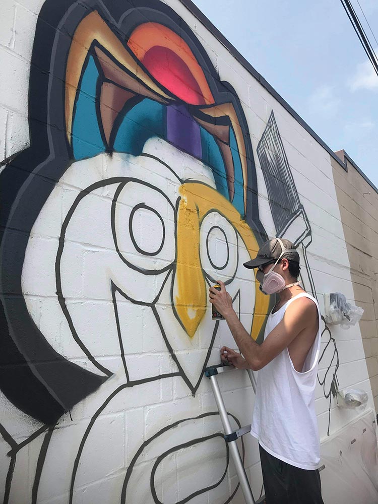 JayFlo working on a mural in downtown Eau Claire