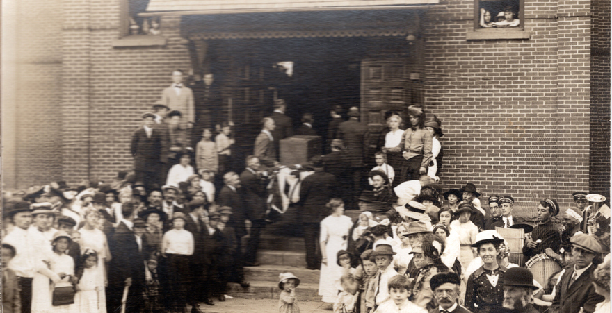 A crowd gathers around Sauk City High School as participants in Ethel Rockwell’s  A Social Center Pageant move the town ballot box from City Hall to the high school  in a gesture that represents the convergence of citizenship and education. Courtesy of the Sauk Prairie Area Historical Society