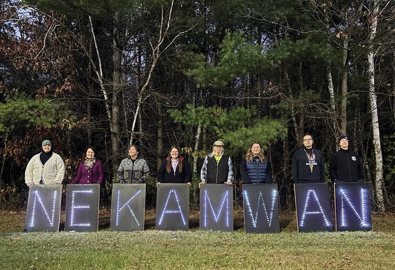 Participants at the first #LanguageBack workshop posed with lighted signs to spell out Neka:mwan, the Mohican word for song.