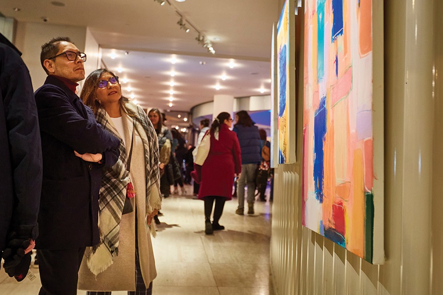 Patrons viewing the collaborative painting by Issis Macias and Rodrigo Carapia at the Latino Art Fair, which featured the music of the Afro-Cuban All Stars at Overture Center. Photo by Martin Jenich