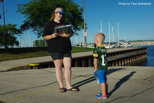 Tabitha (a volunteer in AIS prevention) takes advantage of a lull in boat launches to educate a child on AIS.