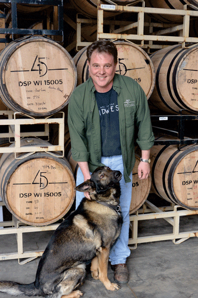 45th Parallel  Distillery owner Paul Werni and his dog, Jack, in the rick house. Photo by Brenda K. Bredahl.