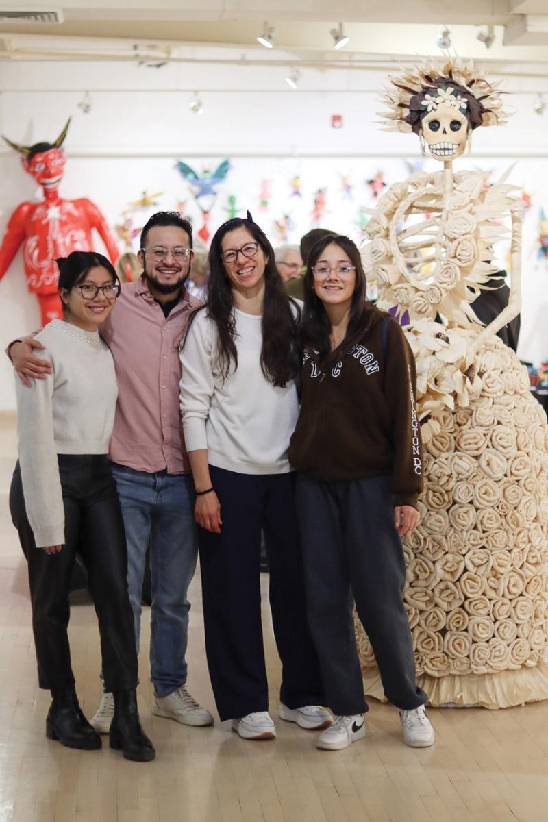 Exhibiting Artist, Yesica Coria (middle right), stands in front of her artwork, a larger than life corn husk Catrina, as part of Latino Arts’ Celebrating our Shared Roots exhibit. Photo by Latino Arts, Inc.