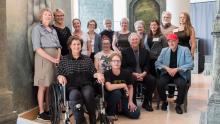 Artist Terese Agnew (in wheelchair after an art-related accident) and her collaborators for the epic Writing in Stone installation. Photo by Studio Indigo Photography.