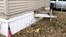 The rusted triangular frame, which once supported the hitch coupler for towing the manufactured home, now serves as a stand for a decorative planter. Credit: Erin Gaede.