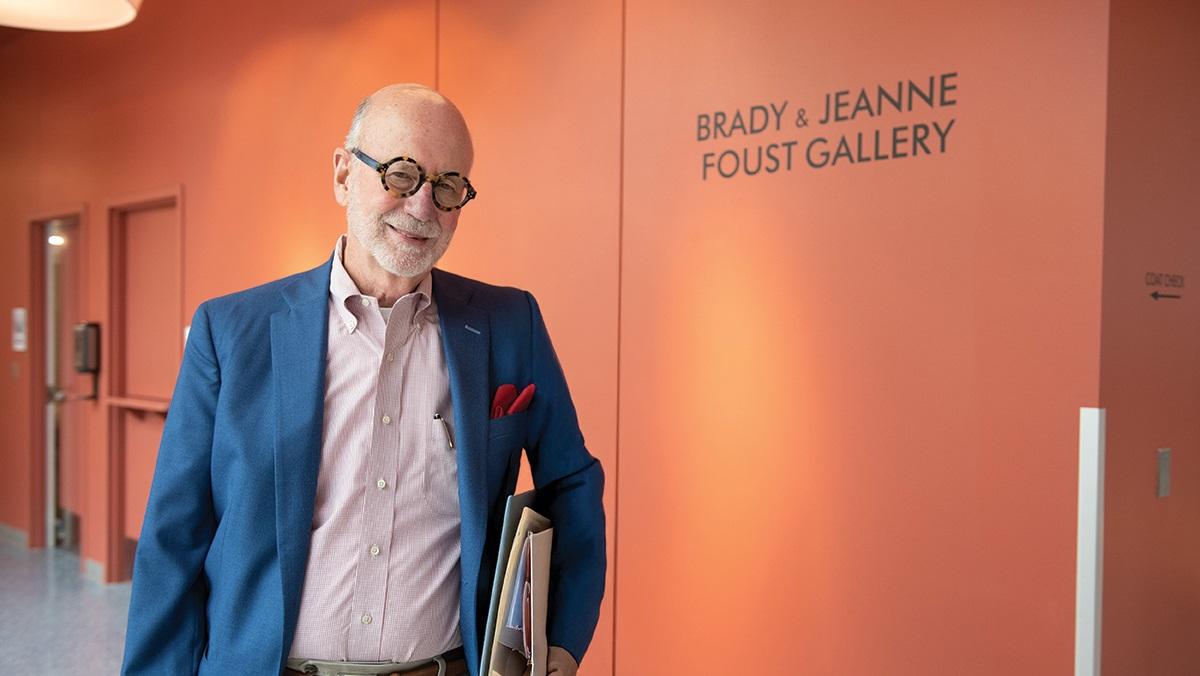 Photo of James Brady Foust in front of the sign for an art gallery he and his wife support