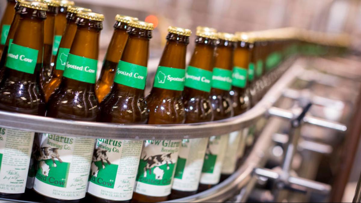 Bottles of New Glarus Brewing Company's signature beer come off the production line. Soon, all New Glarus bottles will be sourced from Ardagh glass manufacturing plant in Burlington, adding another dimension to the Spotted Cow tagline: Only in Wisconsin. Photo by Andy Manis.