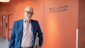 Photo of James Brady Foust in front of the sign for an art gallery he and his wife support
