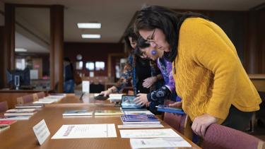 A participant at #LanguageBack looks at books in the library of the College of Menominee Nation.