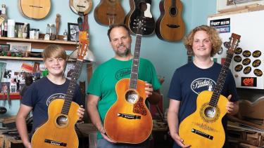Todd Cambio, center, with two of his sons at Fraulini Guitars in Madison.