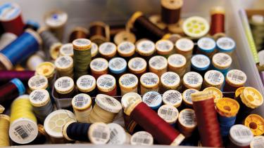 Spools of colored string in a bin